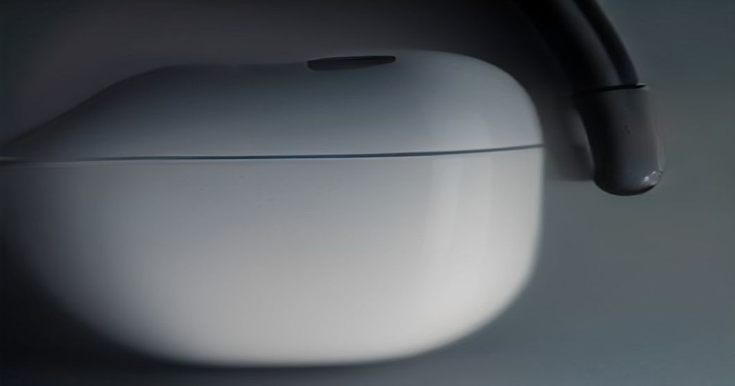 AirPods 5 earbuds shown in their charging case with a subtle glow indicating active noise cancellation